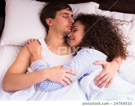 Happy young couple embracing in sleep 24769810