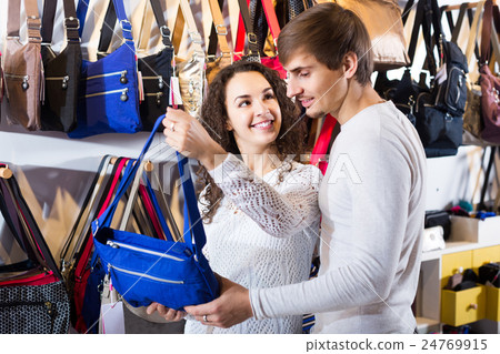 customers looking at stylish female handbags in store 24769915