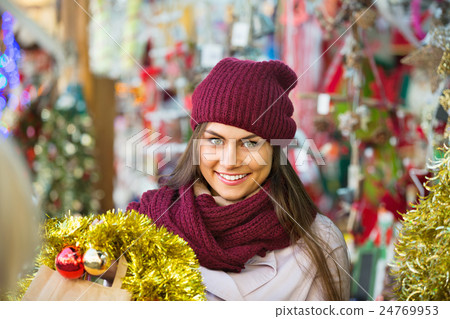 Cheerful smiling woman choosing Christmas decoration 24769953