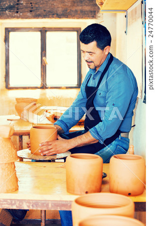 Mature man making pot 24770044