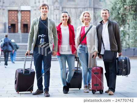 Happy family of four with trunks and bags Happy family of four with trunks and bags 24770742