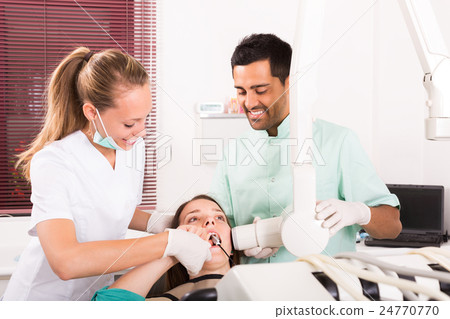 Dentist examines patient at clinic Dentist examines patient at clinic 24770770