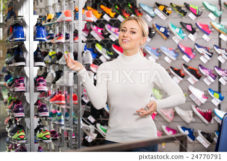 Woman demonstrating shoes in shop Woman demonstrating shoes in shop 24770791