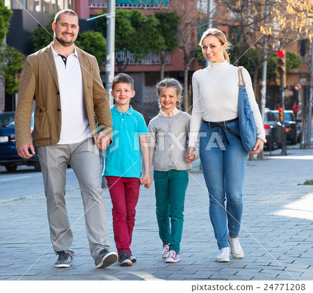 Parents with two teenagers going for shopping outdoors 24771208