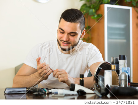 Young guy cutting nails . 24771851