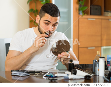 Guy remove hair from his nose 24772002