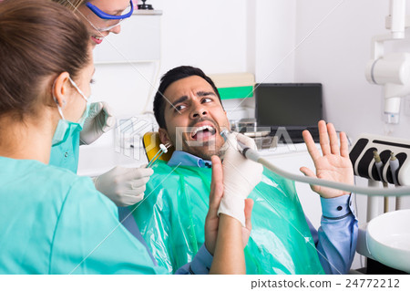 Dentist and scared patient . 24772212