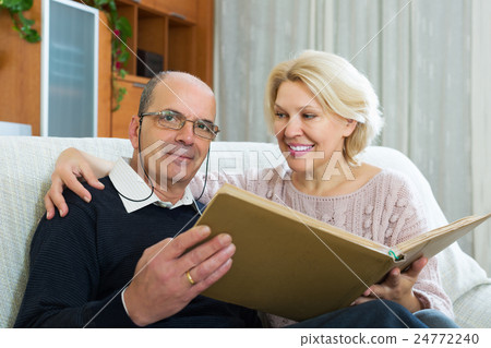 Couple sitting with photograph album 24772240
