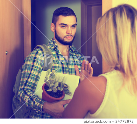 Frustrated couple standing at doorway 24772972