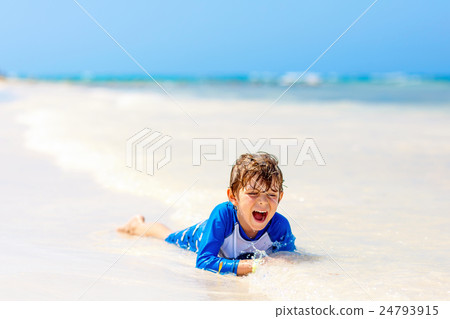 little blond kid boy having fun on tropical beach 24793915