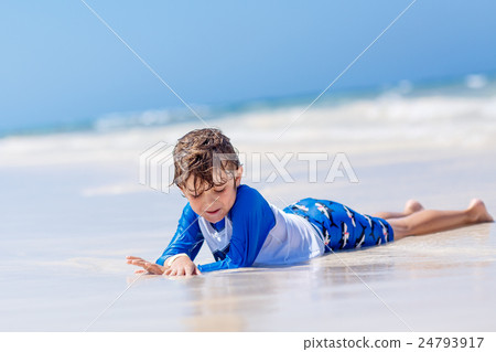 little blond kid boy having fun on tropical beach 24793917