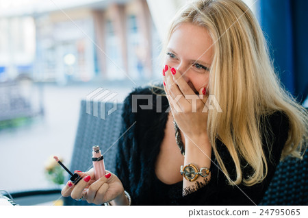 young beautiful blonde girl is sitting in a street 24795065