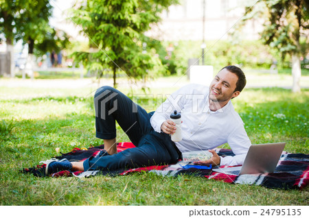 Businessman working in the garden and eating lunch Businessman working in the garden and eating lunch 24795135