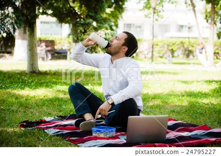 Businessman working in the garden and eating lunch Businessman working in the garden and eating lunch 24795227