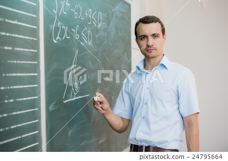 Young male teacher or student holding chalk Young male teacher or student holding chalk 24795664