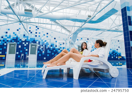 Two beautiful women are lying on chaise-longue Two beautiful women are lying on chaise-longue 24795750