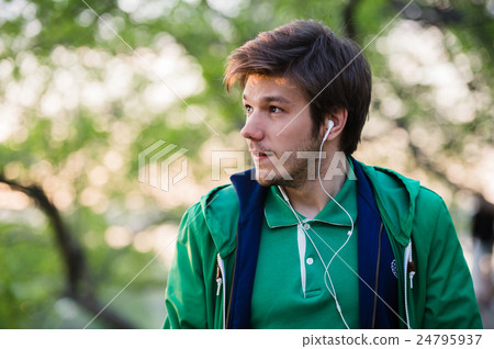 Young man with earphones listening to music 24795937