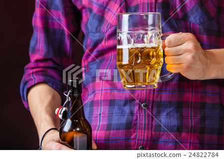 Man holds glass of beer. 24822784