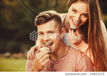 Lovely couple eating cupcakes. 24823314