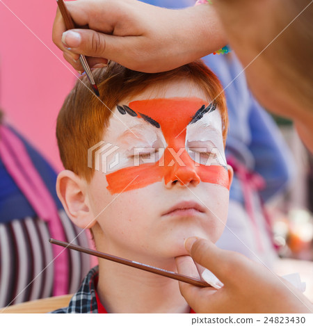 Child boy face painting, making tiger eyes process Child boy face painting, making tiger eyes process 24823430