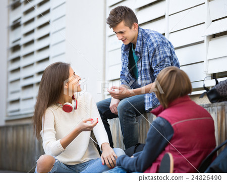Three teenagers hanging out outdoors 24826490