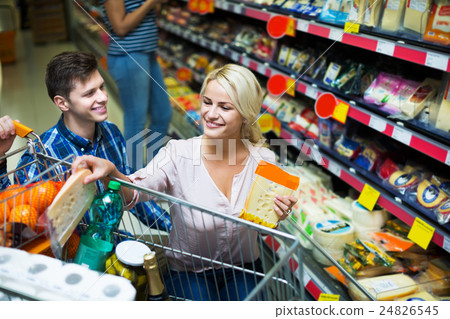 Couple choosing cheese at shop 24826545