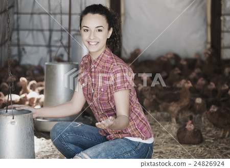 Happy woman farmer giving feeding stuff Happy woman farmer giving feeding stuff 24826924