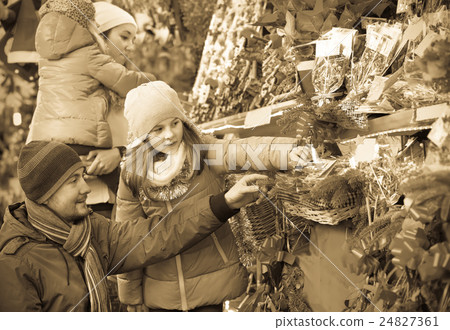 Family standing at coniferous souvenirs counter Family standing at coniferous souvenirs counter 24827361