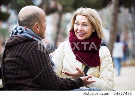 Mature couple chatting in street 24827486