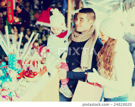 Happy family choosing Christmas decoration at Christmas market 24828020