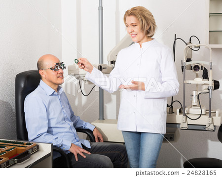Adult optician examinating eyesight Adult optician examinating eyesight 24828165