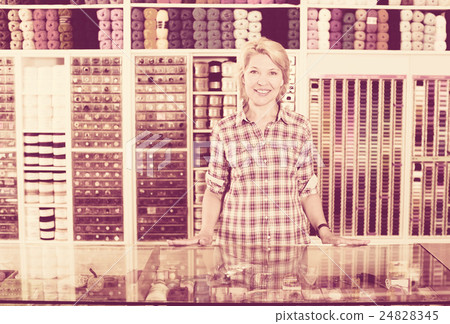 Woman seller standing in sewing store 24828345