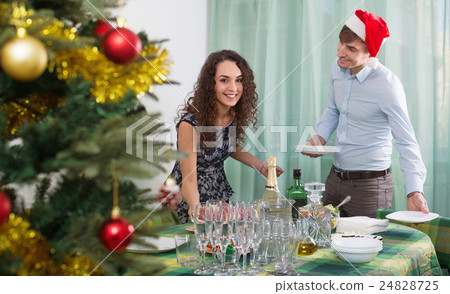 Positive happy man and girl serving Christmas table Positive happy man and girl serving Christmas table 24828725