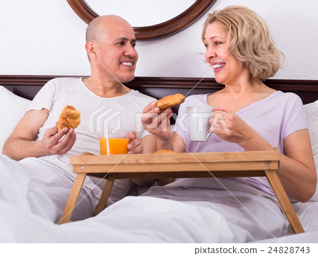 Mature couple having breakfast in bed. 24828743