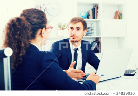 portrait of business man sitting with computer in office on wor portrait of business man sitting with computer in office on wor 24829030