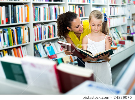 Woman showing open book to little girl 24829070