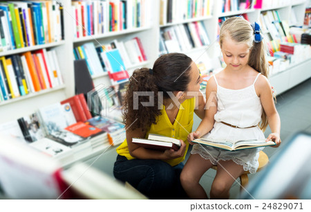Woman showing open book to little girl 24829071