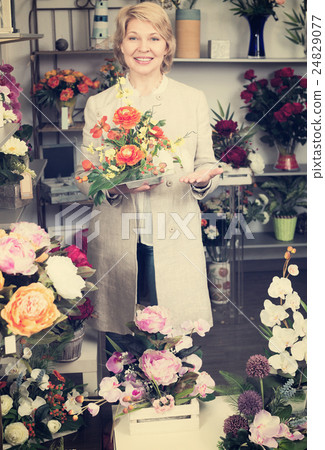 Woman smiling among multicolored flowers 24829077