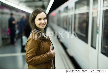 Cheerful female passanger standing at arrival platform Cheerful female passanger standing at arrival platform 24829499