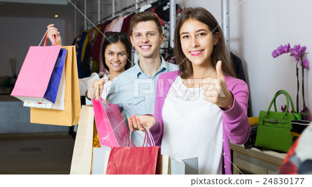 adults in good mood holding bags at clothing store 24830177