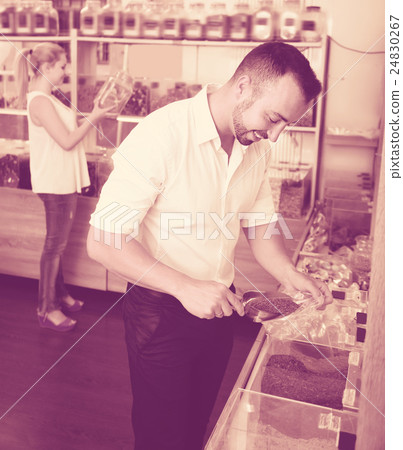 Adult man taking with scoop cereals sold 24830267