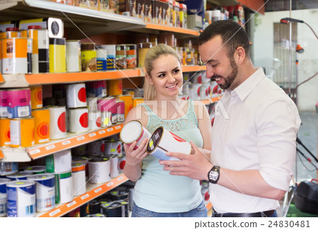 man and woman picking paint tin together in household shop man and woman picking paint tin together in household shop 24830481