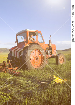 Mongolian Farmer Driving His Tractor On The Field Concept 24833083