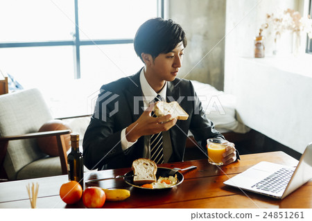 Businessman eating breakfast 24851261