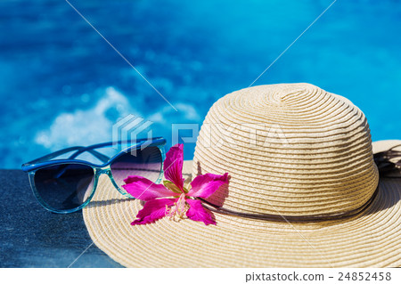 Sunglasses with flower and hat on swimming pool Sunglasses with flower and hat on swimming pool 24852458