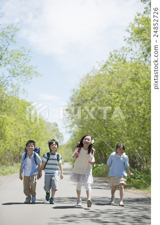 Elementary school students walking on one road Elementary school students walking on one road 24852726