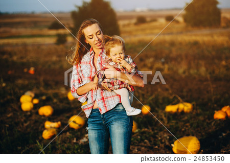 mother and daughter on a field with pumpkins 24853450