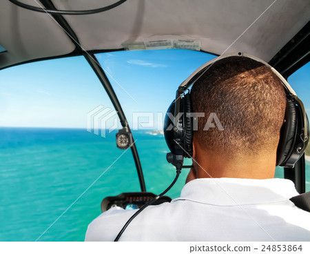 Helicopter pilot in flight with caribbean sea view 24853864