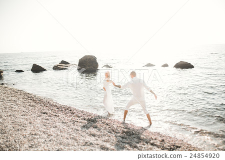 Wedding couple kissing and hugging on rocks near 24854920