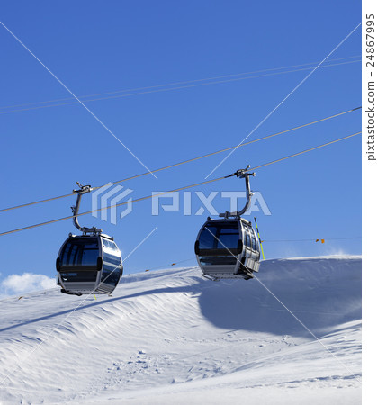 Gondola lift on ski resort at windy sun day 24867995